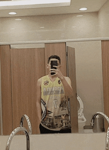 a man is taking a picture of himself in a bathroom mirror wearing a jersey that says aguila