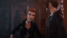 a woman in a black jacket is standing next to a man in a dark room .