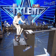 a person on a bike in front of a sign that says got talent espana