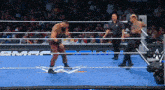 a man in a wrestling ring with a referee and a sign that says wwe on it