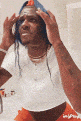 a man in a white shirt and orange shorts looks at himself in a bathroom mirror