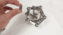 a person is holding a cube made of magnets