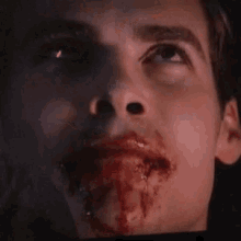 a close up of a man 's face with blood on his mouth .