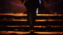 a woman holding a knife in a dark room with the letter m in the corner