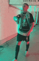 a man holding a trophy and wearing a shirt that says " radinha "