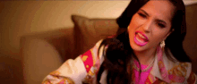 a woman is sitting on a couch making a funny face .