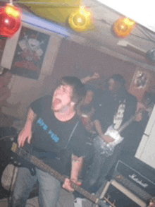 a man playing a guitar in a band wearing a shirt that says life for