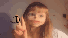 a girl is making a face with her finger and the letter d is drawn on her finger