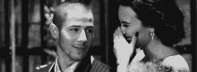 a black and white photo of a man and a woman laughing .