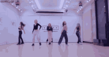 a group of girls are dancing in a room with a sign that says sechember