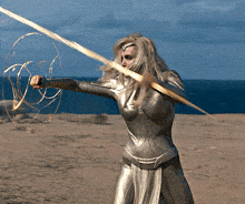 a woman in a superhero costume holds a golden sword