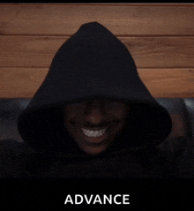 a man wearing a black hoodie is smiling and the word advance is behind him