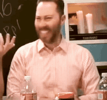 a man in a pink striped shirt is smiling in front of a cabinet that says fairbanks