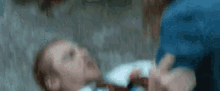 a blurry picture of a man laying on the ground with a woman holding his arm .