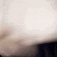 a close up of a person 's face with a white background and a blurred background .