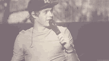 a black and white photo of a man holding a microphone that says fuckyeah1d on the bottom