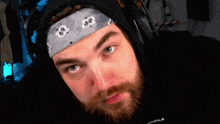 a man with a beard wearing headphones and a bandana with the number 80 on it