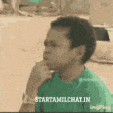 a boy in a green shirt is smoking a cigarette with the words starttamilchat.in on the bottom
