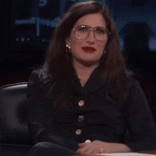 a woman is sitting at a desk with her eyes closed and the word dead written in front of her