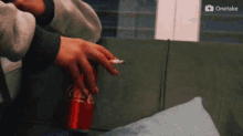 a person smoking next to a coca cola can