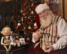 santa claus is sitting in front of a christmas tree