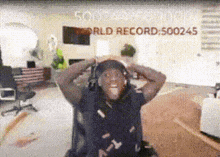 a man wearing headphones is sitting in front of a world record sign