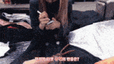 a woman sitting in front of a suitcase holding a pen and writing