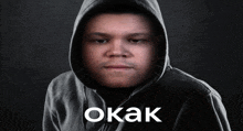 a man in a hooded sweatshirt with the word okak written on the bottom