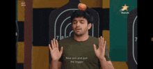 a man with a ball on his head and the words now aim and pull the trigger on his shirt