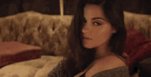 a woman is laying on a couch and looking over her shoulder