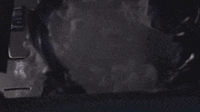 a person is standing in a dark room with smoke coming out of it .