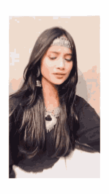 a woman wearing a headband and earrings is looking down