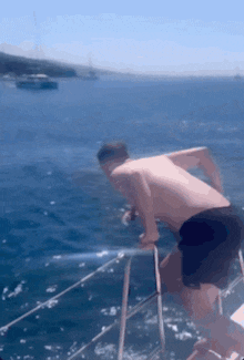 a man without a shirt is jumping off a boat into the water