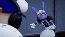 a purple cartoon character wearing a maid outfit is standing next to a person wearing headphones .