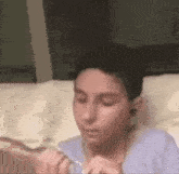 a young boy is laying on a bed eating food with a fork .