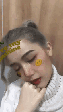 a girl with a sticker on her face that says be my sunshine