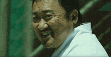 a man with a beard and a white shirt smiles