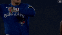 two blue jays players high five each other during a game