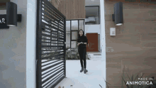 a woman is standing in front of a gate that says made in animatica on it