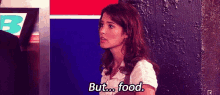 a woman is standing in front of a wall and talking to a man while saying `` but ... food '' .
