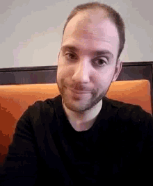a man with a beard and a black shirt is smiling