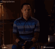 a man in a blue and gray striped shirt is sitting in a chair with youtube originals written on the bottom right