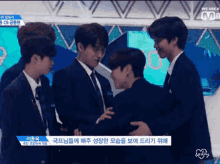a group of young men are standing next to each other on a stage with a sign that says we are k on it