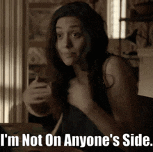 a woman is sitting at a table with the words i 'm not on anyone 's side above her .