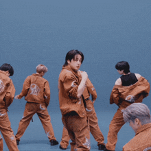 a group of young men are dancing on a blue stage