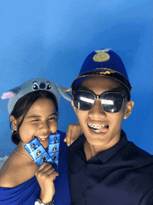 a boy wearing sunglasses and a girl wearing a hat with stitch on it