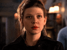 a close up of a woman 's face with red lipstick and earrings
