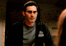 a man wearing glasses and a black hoodie with a logo that says boston on it