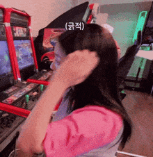 a woman adjusts her hair in front of an arcade machine that says monkey
