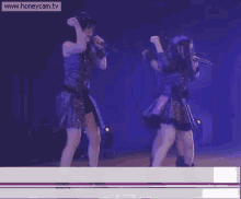 two women dancing on a stage with the website www.honeycam.tv at the bottom